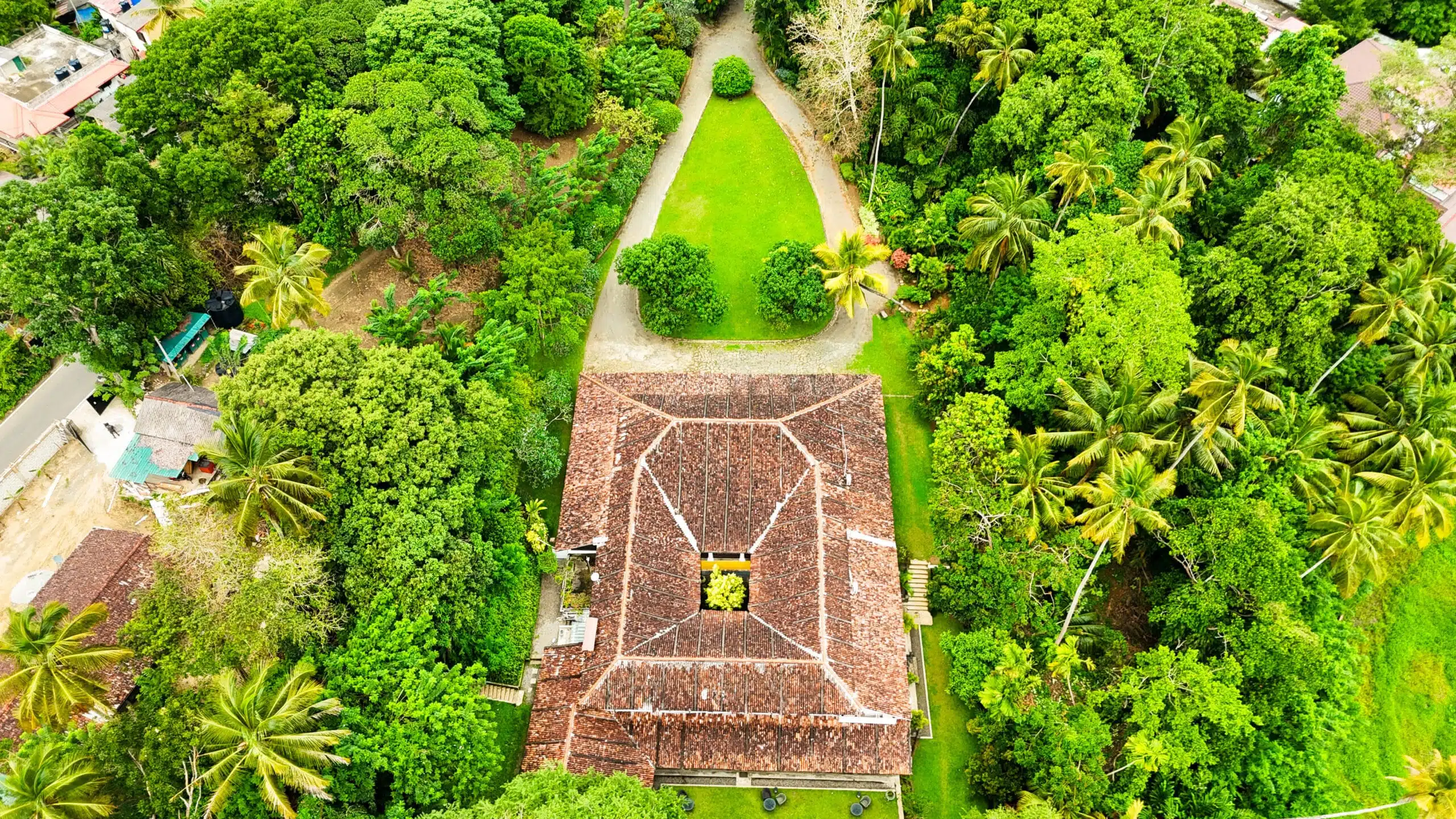 Adigar’s Manor a Kandy ne vale la pena? La nostra recensione onesta (2026) 25 Veduta aerea dell'Adigar’s Manor che mostra la storica Walauwa del 1804 circondata dal verde tropicale, inclusa nella sezione storica della guida agli hotel boutique a Kandy.
