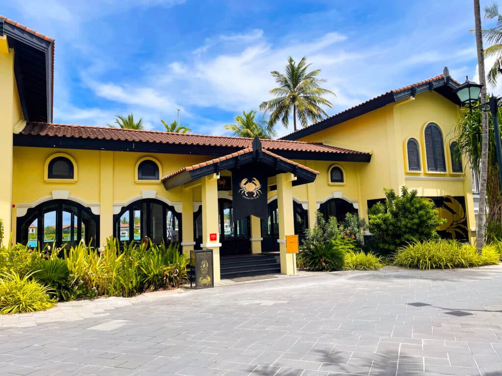 Yellow Ministry of Crab restaurant building surrounded by palm trees near Hard Rock Hotel Maldives.