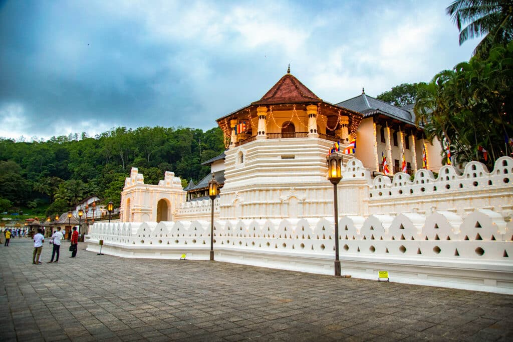 Les meilleures villes à visiter au Sri Lanka : un guide pratique des régions, itinéraires et points de chute 5 Le Temple of the Tooth Relic à Kandy au crépuscule, avec ses murs blancs, son architecture traditionnelle et les collines verdoyantes environnantes.