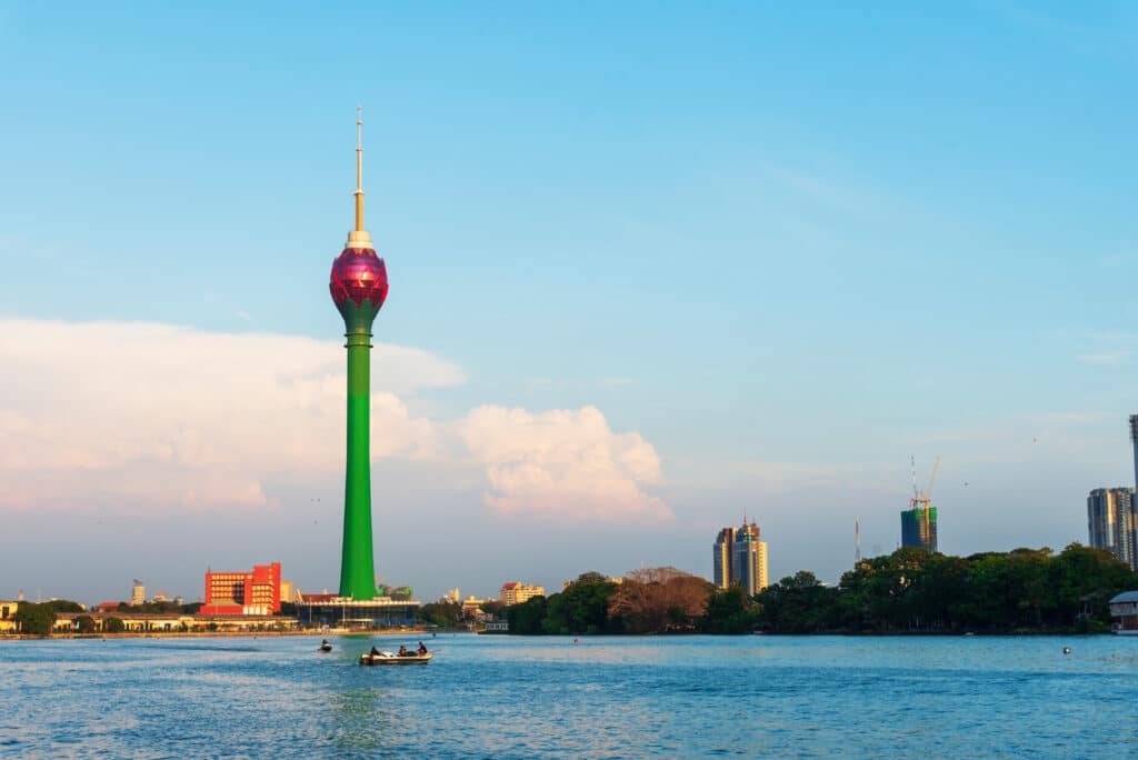 The colorful Lotus Tower rises above the lake and skyline of Colombo in clear afternoon light.