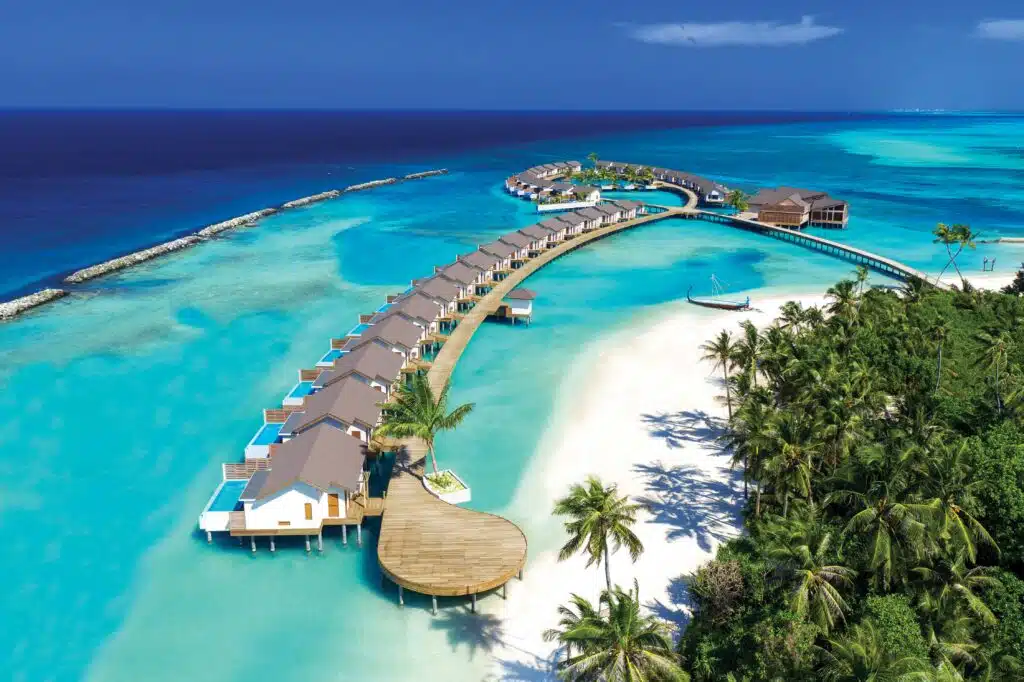 I migliori hotel alle Maldive: resort di lusso, boutique hotel e soggiorni convenienti 18 veduta aerea di una fila curva di ville sull'acqua con piscina privata accanto a una spiaggia bianca e una laguna turchese