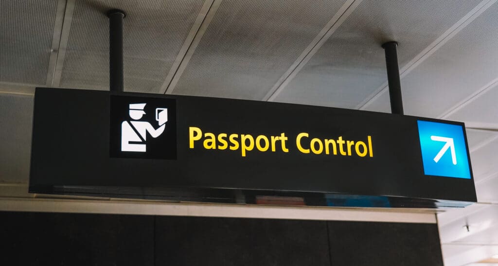 Airport sign directing arriving passengers toward passport control and immigration.