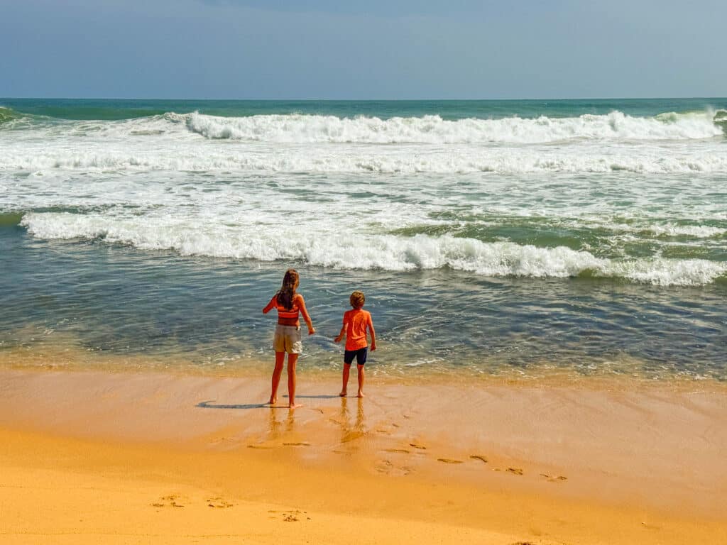 Kinderen die spelen op een breed zandstrand langs de zuidkust van Sri Lanka