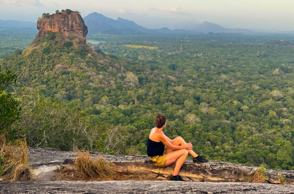 Meteo in Sri Lanka ad agosto: stagione balneare sulla costa orientale e guida di viaggio regionale 9 Viaggiatore seduto su Pidurangala Rock con vista sulla Sigiriya Lion Rock in Sri Lanka