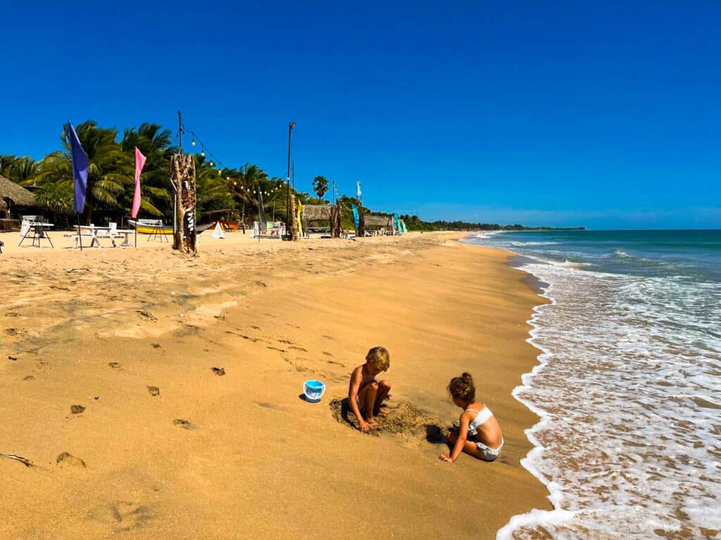 Itinerario di 7 giorni in Sri Lanka: Kandy, la regione collinare e la costa 17 due bambini che giocano nella sabbia su un'ampia spiaggia dorata a Trincomalee Sri Lanka