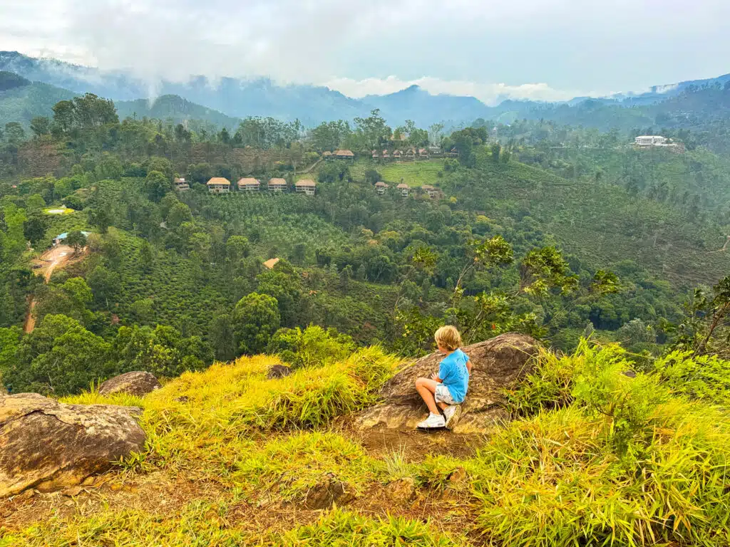Le migliori cose da fare in Sri Lanka: le esperienze più gratificanti sull'isola 8 Bambino seduto su una roccia a Little Adam's Peak con vista sulle colline nebbiose coperte di tè — le migliori cose da fare in Sri Lanka