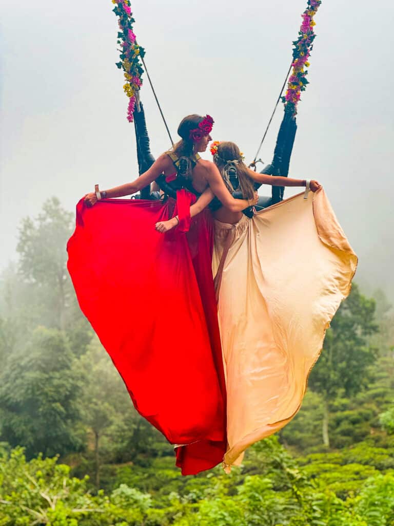 Itinerario di 7 giorni in Sri Lanka: Kandy, la regione collinare e la costa 7 due donne su un'altalena decorata con fiori sopra le nebbiose colline del tè a Ella, in Sri Lanka