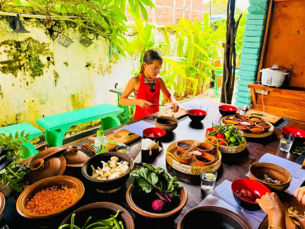 Le migliori cose da fare in Sri Lanka: le esperienze più gratificanti sull'isola 18 Ragazza che taglia verdure a un tavolo da cucina allestito con spezie fresche e ingredienti a Galle Fort, Sri Lanka