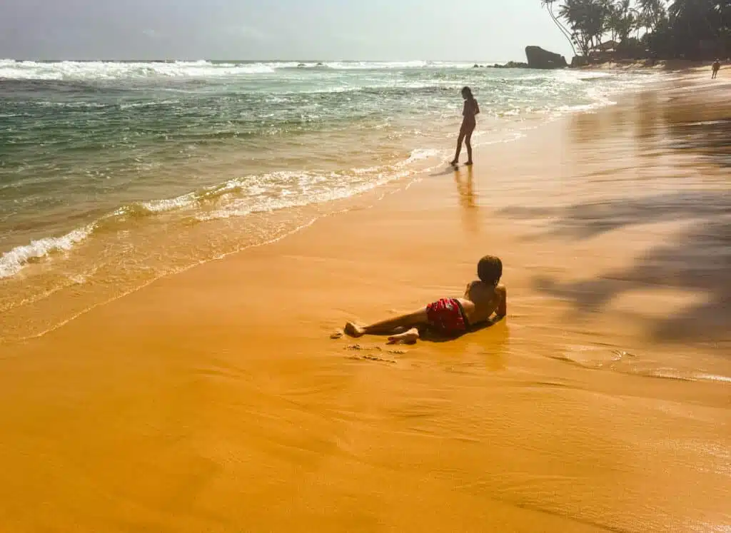 Le migliori cose da fare in Sri Lanka: le esperienze più gratificanti sull'isola 11 Due bambini che giocano su una spiaggia di sabbia dorata con onde turchesi a Unawatuna, Sri Lanka
