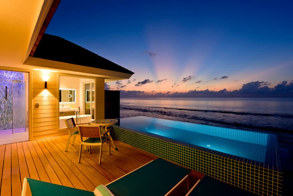 Los mejores resorts de Maldivas con mejor relación calidad-precio: 10 islas privadas que superan su precio 14 terraza de villa sobre el agua con piscina infinita iluminada y vista al atardecer sobre el océano en Kandima Maldives