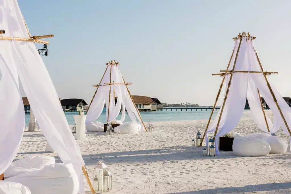 Isole locali delle Maldive vs Resort: cosa dovresti scegliere? 15 Testo alternativo:
allestimento romantico sulla spiaggia con teepee drappeggiati di bianco e lanterne su un banco di sabbia presso Como Cocoa Island Maldives