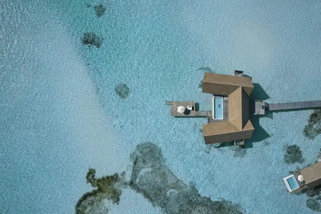 I migliori resort alle Maldive vicino a Malé: 10 isole top vicine all'aeroporto 16 vista aerea delle ville sull'acqua di COMO Cocoa Island a forma di barche dhoni tradizionali maldiviane
