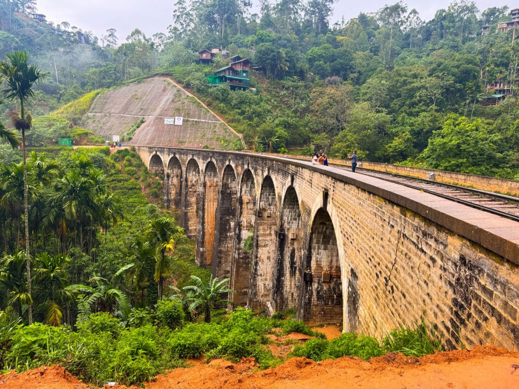 Sri Lanka Hill Country: Tea Plantations, Train Rides & Cool Climate Escapes 7 Nine Arch Bridge Ella with a train crossing the stone viaduct surrounded by jungle and tea estates