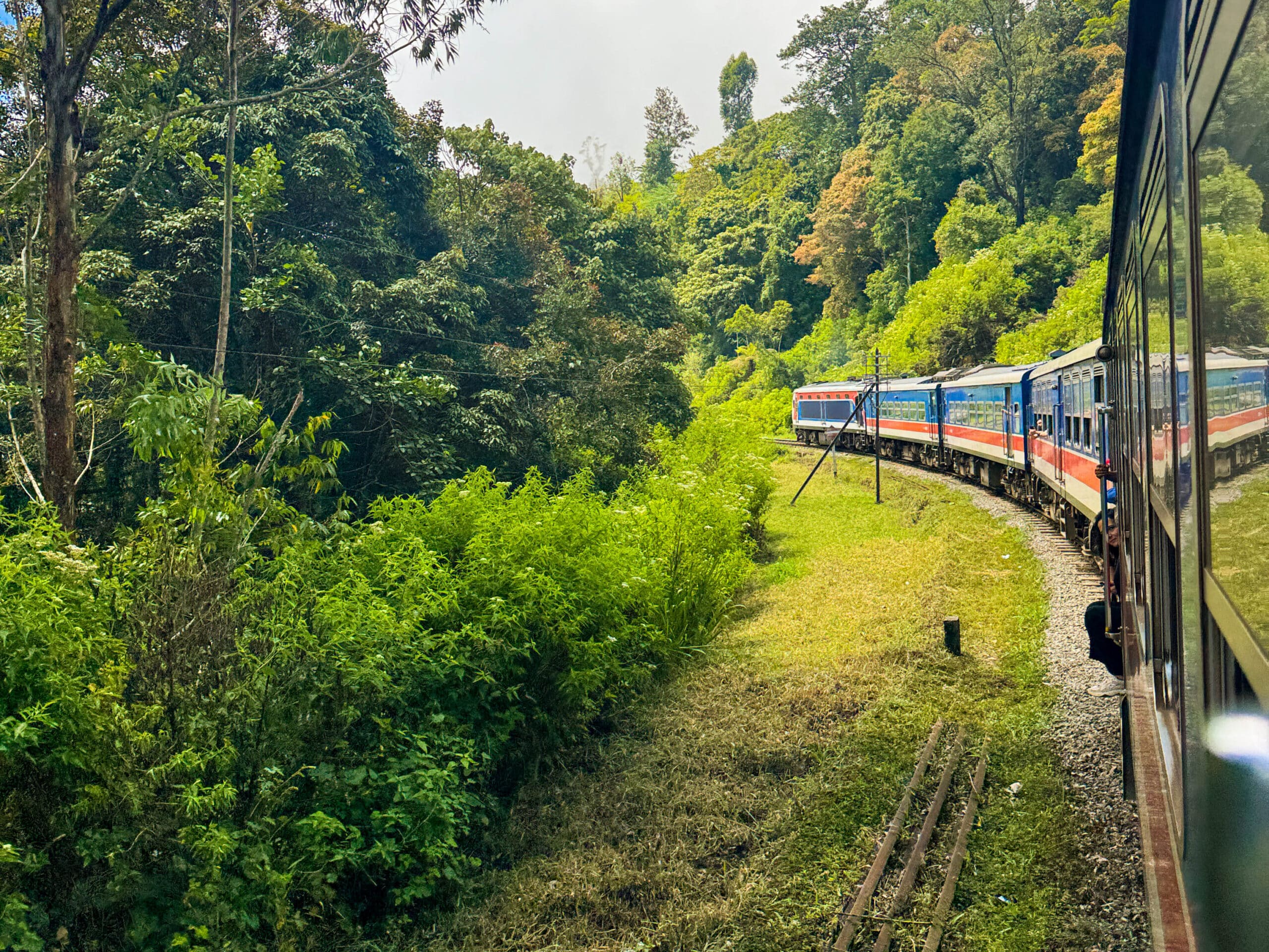 Kandy to Ella Train Ride: Best Seats, Stops & Hotels Along the Route 15 Kandy to Ella train winding through lush green Sri Lanka hill country