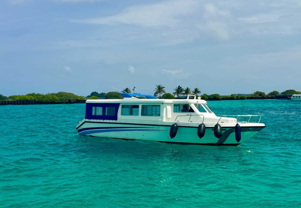 Isole locali delle Maldive vs Resort: cosa dovresti scegliere? 14 traghetto pubblico in motoscafo su acqua turchese in avvicinamento a un'isola locale delle Maldive