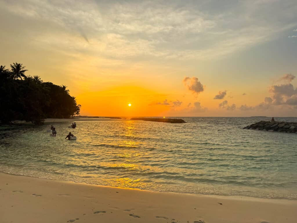 Le Maldive valgono la spesa? Un confronto onesto con lo Sri Lanka 5 tramonto dorato su una spiaggia di sabbia bianca su un'isola locale alle Maldive con gente del posto che pesca in acqua