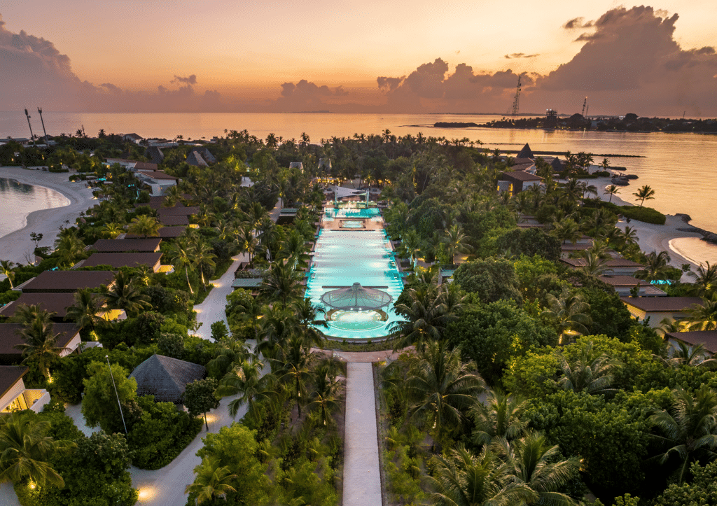 I migliori resort alle Maldive per chi visita per la prima volta: 10 isole che rendono tutto più semplice 21 vista aerea del Kuda Villingili Resort Maldives al tramonto con piscina illuminata circondata da giardini tropicali