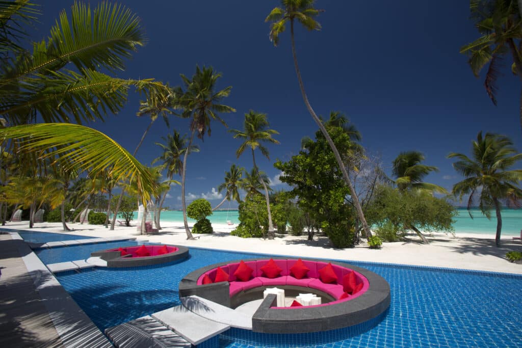 I migliori resort alle Maldive per chi visita per la prima volta: 10 isole che rendono tutto più semplice 20 piscina colorata con sedute circolari all'interno dell'acqua al Kandima Maldives con spiaggia e palme sullo sfondo
