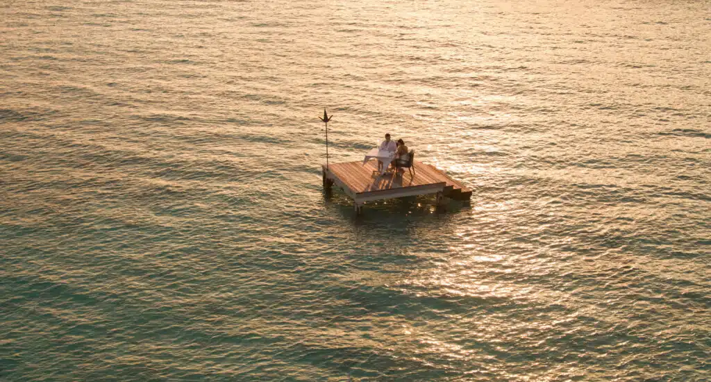 How to Choose a Maldives Resort: The Complete Decision Guide 19 couple dining on private overwater platform at Four Seasons Landaa Giraavaru Maldives at golden sunset