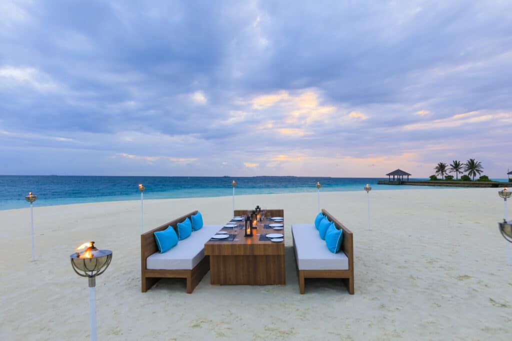 I migliori resort alle Maldive vicino a Malé: 10 isole top vicine all'aeroporto 11 tavolo da pranzo sulla spiaggia apparecchiato per due al Velassaru Maldives con l'oceano turchese sullo sfondo