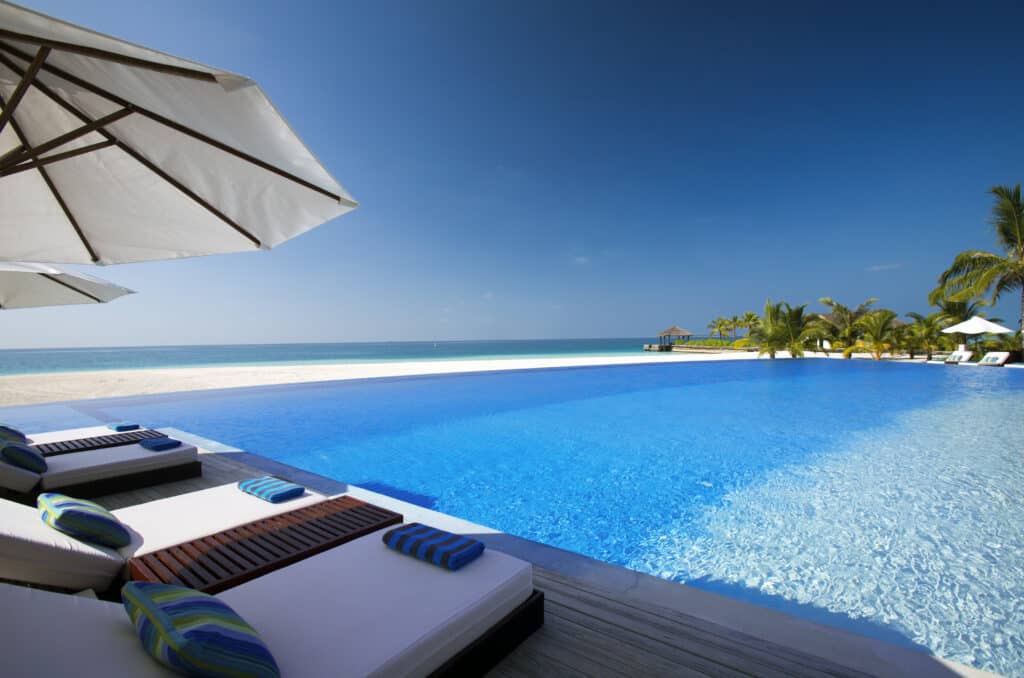I migliori resort alle Maldive per chi visita per la prima volta: 10 isole che rendono tutto più semplice 5 grande piscina a sfioro fronte spiaggia presso Velassaru Maldives con lettini, spiaggia di sabbia bianca e vista sull'oceano