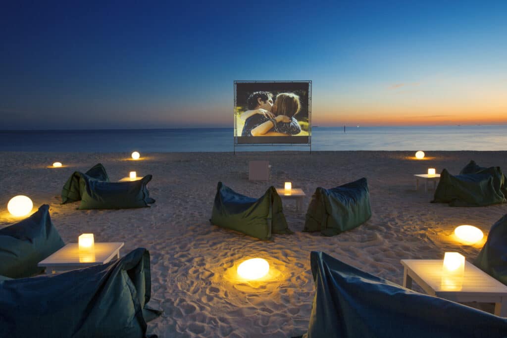 سينما الشاطئ في الهواء الطلق في Velassaru Maldives عند الغسق مع أكياس الفول وشاشات الفيلم