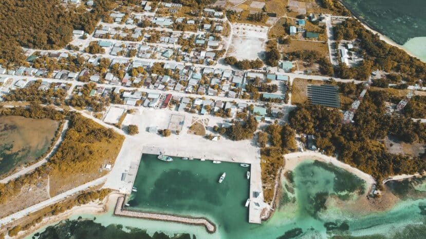 Dhiffushi Maldives: Budget Island with Easy Transfers 1 aerial view of the local island of Dhiffushi with buildings and a sports pitch ringed by turquoise water