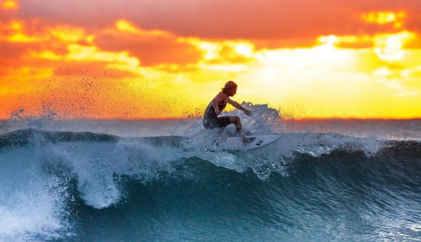 Thulusdhoo Maldives: The Best Local Island for Surfing, Budget Stays & Easy Island Life 1 surfer riding a breaking wave at sunset off Thulusdhoo