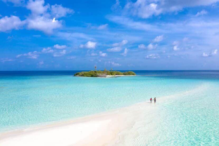 Dhiffushi Maldives: Budget Island with Easy Transfers 9 two people walking along a white sandbank into a turquoise lagoon near an uninhabited island