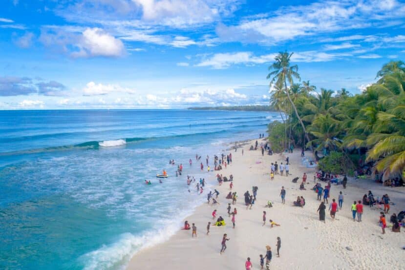 Thulusdhoo Maldives: The Best Local Island for Surfing, Budget Stays & Easy Island Life 2 aerial view of a busy palm-lined local island beach with turquoise water on Thulusdhoo