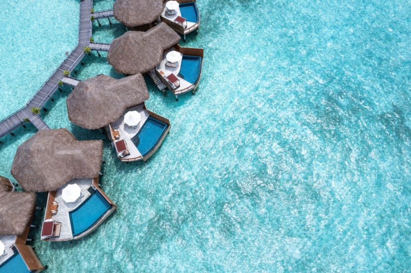 North and South Malé Atoll Guide (Kaafu Atoll): Resorts, Local Islands & Everything You Need to Know 6 Baros Maldives aerial view with water pool villas and overwater bungalows at sunset