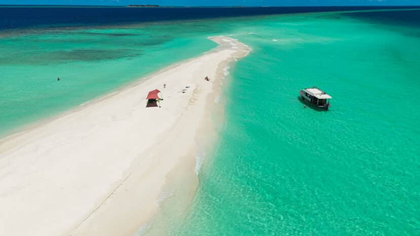 Dhigurah Maldives: The Best Local Island for Whale Shark Encounters 12 aerial view of a long white sandbank stretching into turquoise water with a boat moored alongside