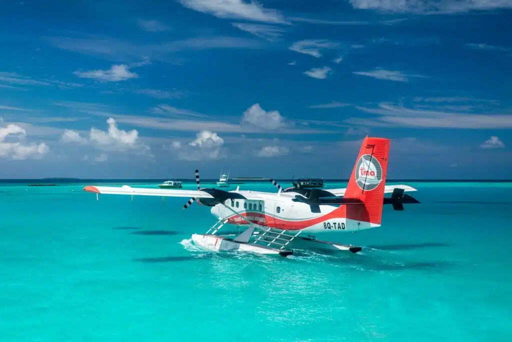 How to Get Around Maldives: The Complete Transport & Transfer Guide 3 seaplane flying low over turquoise Maldives atoll lagoon