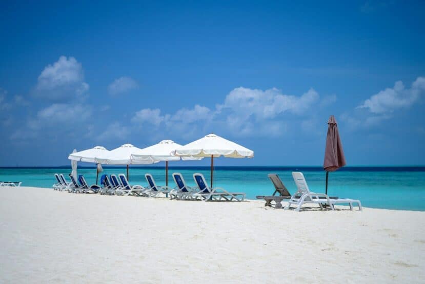Gulhi Maldives: Affordable Local Island Close to Malé 2 sun loungers and umbrellas on a white sand bikini beach beside a turquoise lagoon on Gulhi